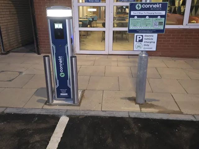 Pay-as-you-go charger with bollards by a hotel entrance